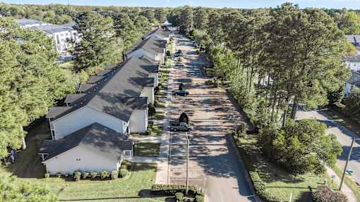 A long row of houses with trees on the side.