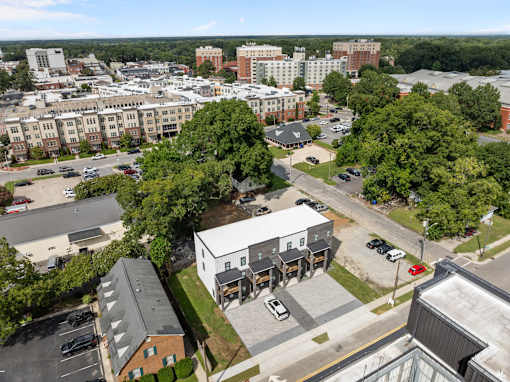 A bird's eye view of a city with buildings, cars, and trees.