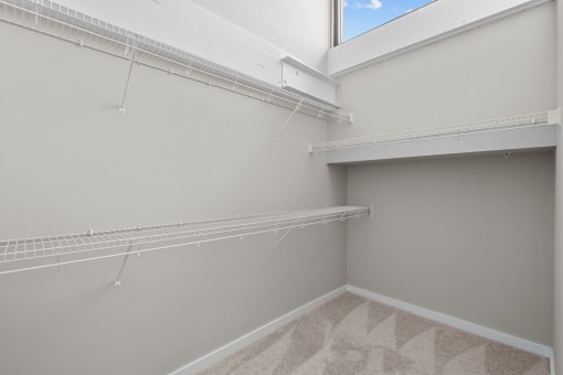 a spacious closet with shelves and a large window in a home with grey walls at Spinning Mill Lofts, Clayton, NC 27520