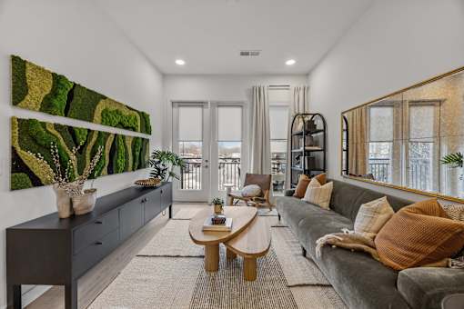A living room with a grey couch and a large painting on the wall.at Adler Montford Park + Drexel Townes, Charlotte, NC, 28209