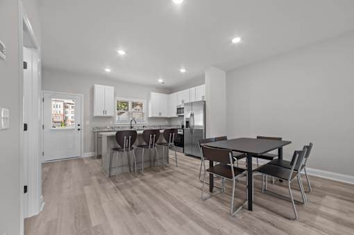A kitchen with a table and chairs in the middle of the room.