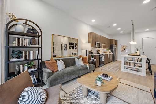 A living room with a grey couch, a coffee table, and a bookshelf.at Adler Montford Park + Drexel Townes, Charlotte, NC, 28209