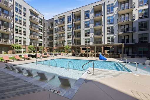 A large swimming pool in front of apartment buildings.