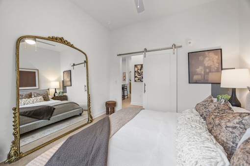A bedroom with a large bed and a large mirror.at Adler Montford Park + Drexel Townes, Charlotte, NC, 28209