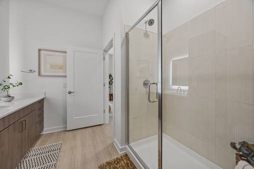 A bathroom with a walk-in shower and a plant on the counter.at Adler Montford Park + Drexel Townes, Charlotte, NC, 28209