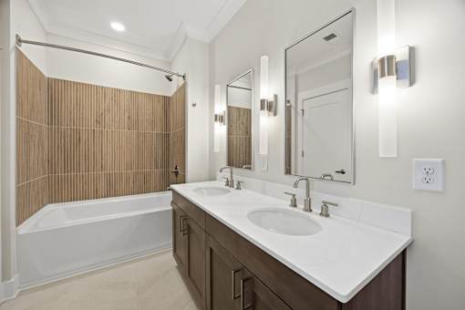 A bathroom with a white sink and a wooden wall.