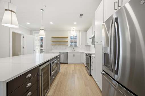 A modern kitchen with stainless steel appliances and wooden floors.