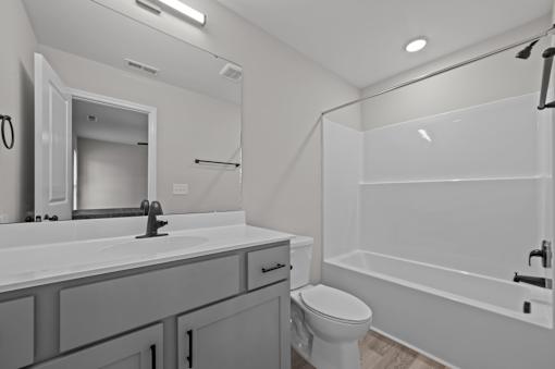 A white bathroom with a toilet, sink, and bathtub.