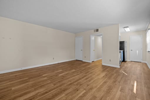 the living room and dining room of an apartment with wood flooring
