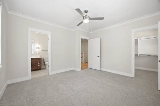 A room with a ceiling fan and carpeted floor.