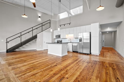 an open kitchen with stainless steel appliances and white cabinets at Spinning Mill Lofts, Clayton, NC 27520