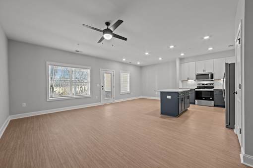 A spacious room with a ceiling fan and wooden flooring.at Regency Townes, North Carolina 