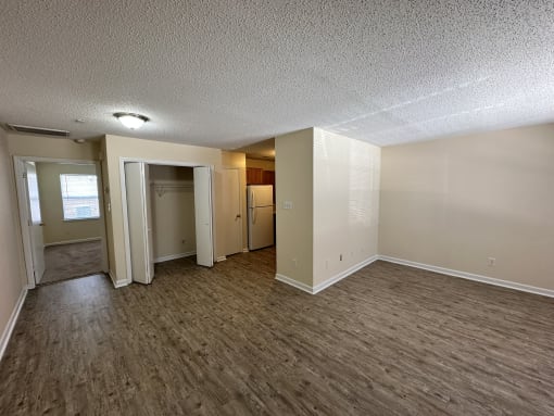an empty living room with wood flooring and white walls