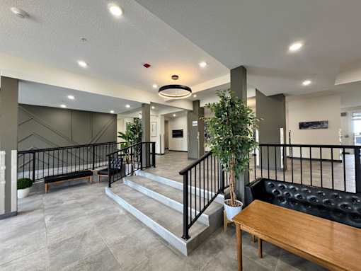 A modern interior with a staircase and a black sofa.