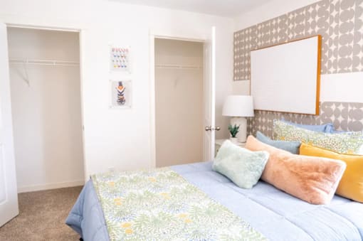 A bedroom with a bed and a lamp.