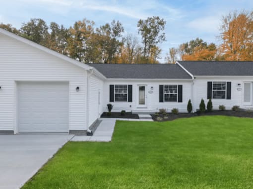 A white house with a grey roof and a grey garage door.