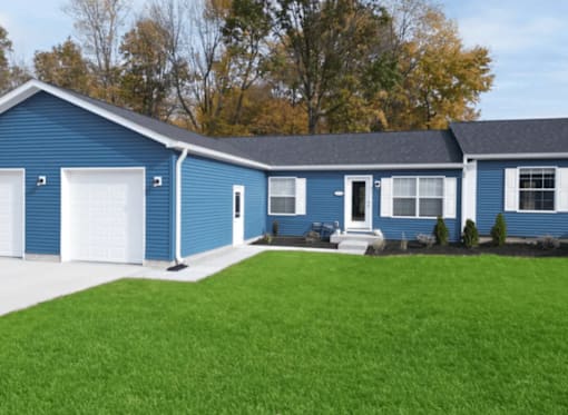 A blue house with a white garage door and a white front door.