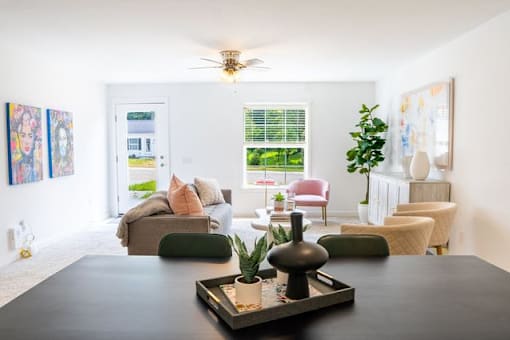 A living room with a black coffee table and a ceiling fan.