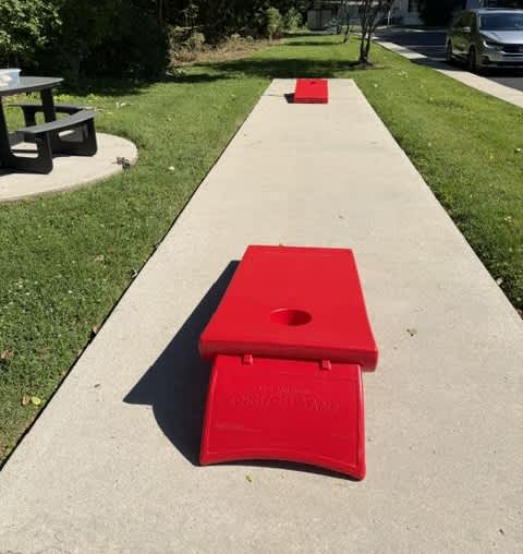 A picnic area with a cornhole game set up.
