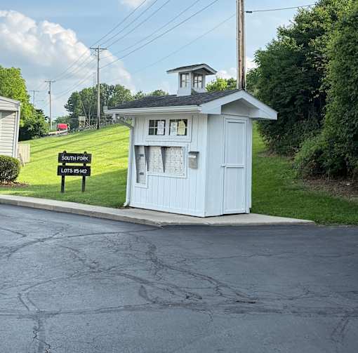A small white building with mailboxes and a sign that says South Fork Lots 15-42.