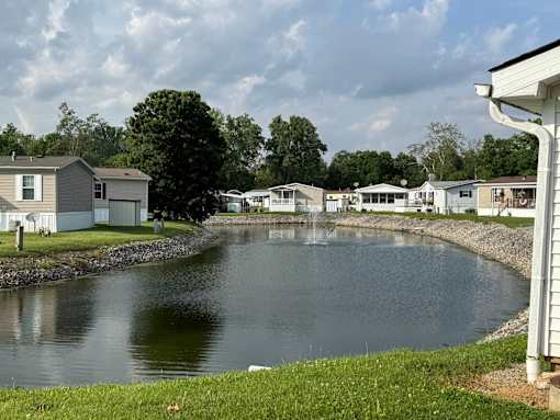 A serene river surrounded by houses and trees.