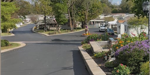 A residential street with houses on both sides and a flower garden.