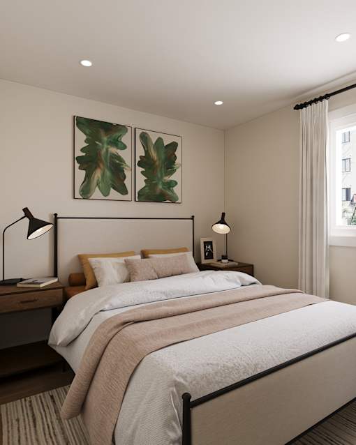 A bedroom with a large bed, a nightstand with a lamp, and two framed leaves on the wall.