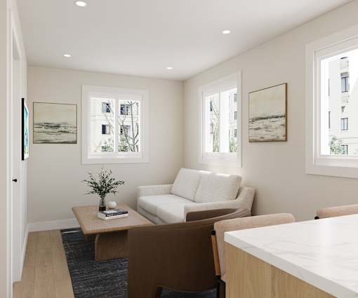 A living room with a white couch, a coffee table, and two framed pictures on the wall.