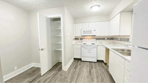 A kitchen with white appliances and cabinets.