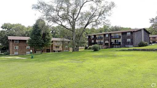 A grassy field with apartment buildings in the background.