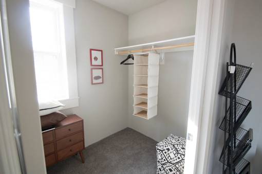 A small bedroom with a dresser and a window.