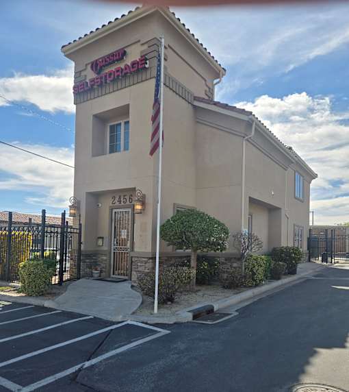 A self storage building with a flag on top.