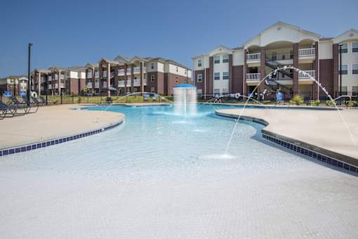 A large swimming pool with a fountain in the middle of it.