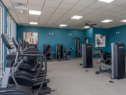 a large fitness room with cardio equipment and exercise machines