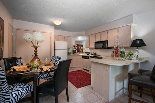 A kitchen with a dining table set for two.