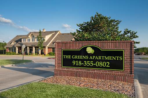 the greens apartments sign in front of the club house