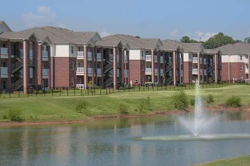 A row of apartment buildings with a fountain in front.