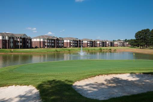 A golf course with a pond and sand traps.