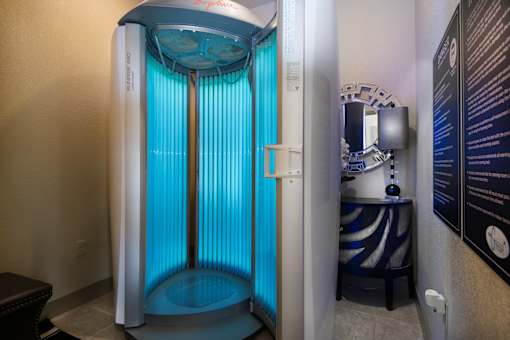 A shower stall with a glass door and a blue light.