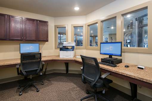 Two computers are on a desk in an office.