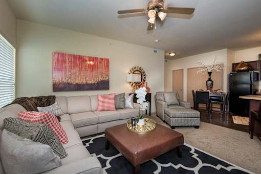 A living room with a grey couch and a brown coffee table.