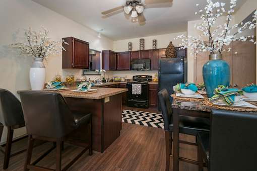 A kitchen with a table and chairs.