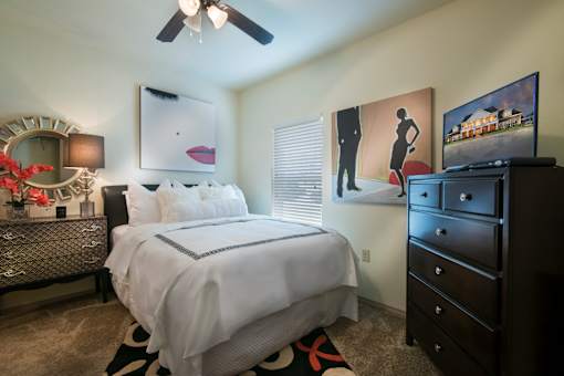 A bedroom with a large bed and a dresser.