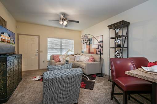 A living room with a grey couch and a red leather chair.