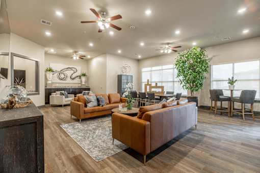 A living room with a brown sofa and a ceiling fan.