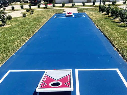 A blue painted court with a pink and white logo on it.