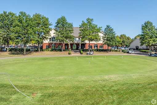 a golf course with a building in the background