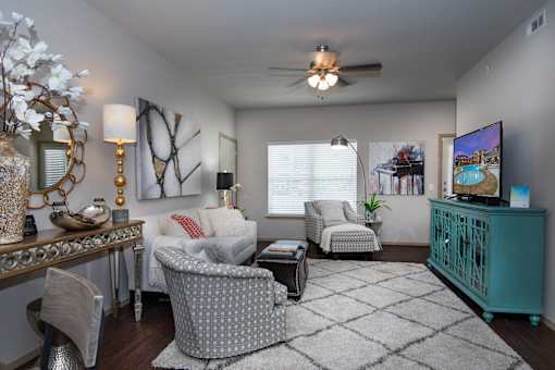 A living room with a grey patterned chair in the center.