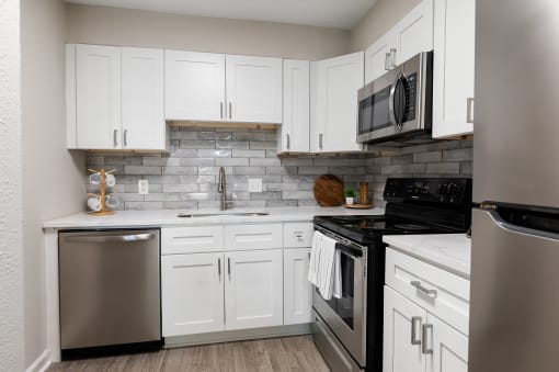 Spacious kitchen with stainless steel appliances and white cabinets in Atlanta