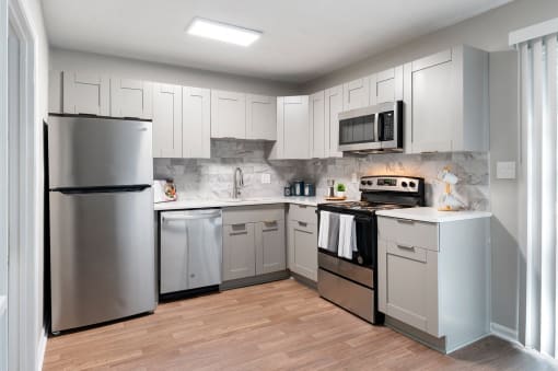 Kitchen with stainless steel appliances and shaker-style cabinets